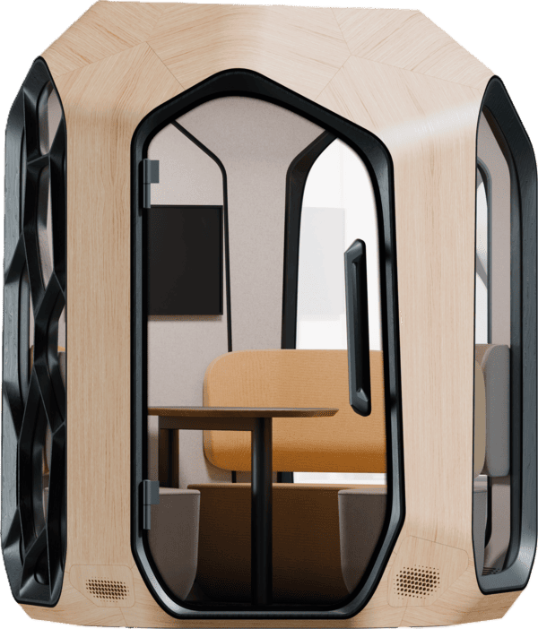 Zbliżenie na front dwuosobowej budki akustycznej wykonanej z jasnego drewna. Przez przeszklone drzwi z czarną ramą widać wnętrze z kanapą o miodowym (żółto-pomarańczowym) oparciu oraz ciemny stolik. Na tylnej ścianie zamontowany jest czarny monitor. Po lewej stronie widoczny jest fragment czarnego panelu z wzorem Voronoi.